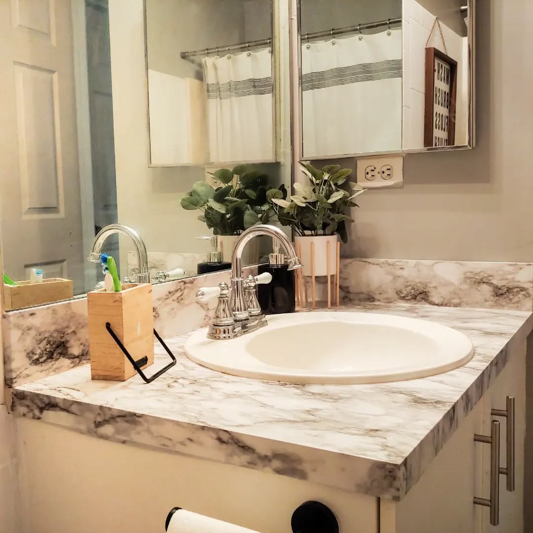 12. a Teal Ceramic Vase with Faux Eucalyptus Beside a Polished Chrome Faucet
