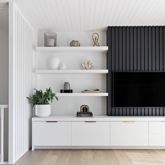 16. a Trio Of Floating Shelves with Geometric Vases and Foliage Above a Sleek Black Tv