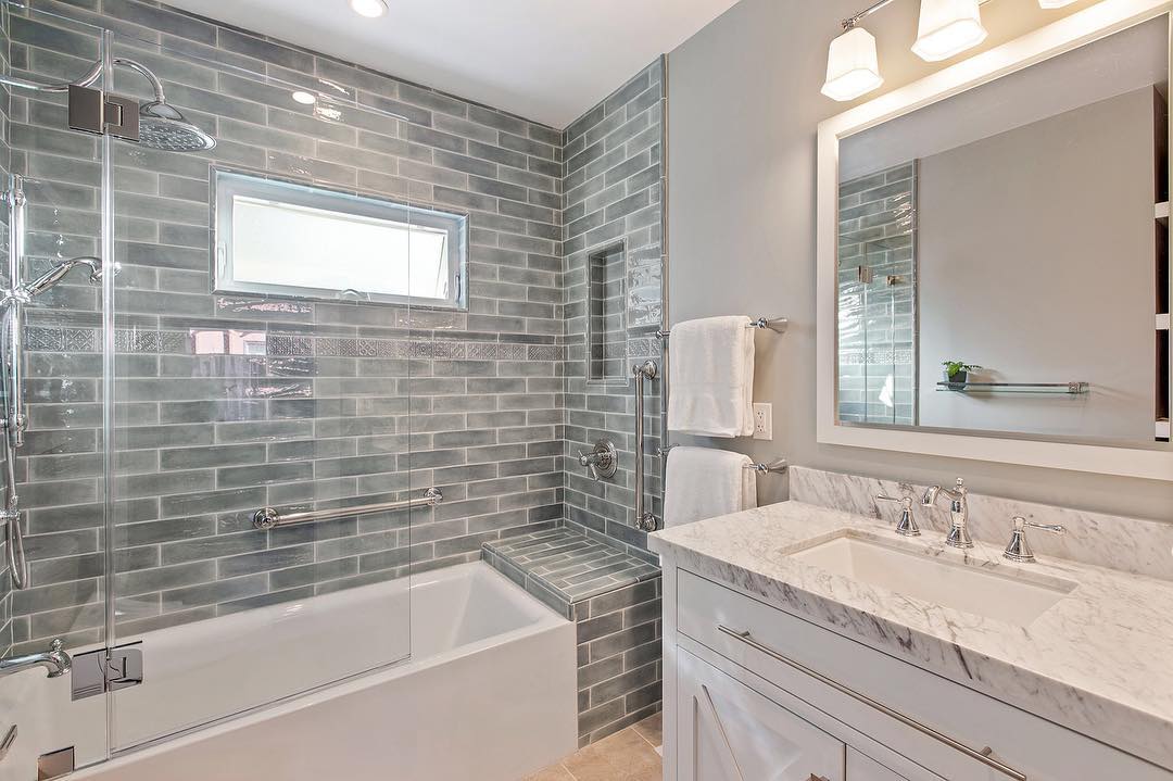 20. Moonlit Mosaic: a Tub and Shower Combo with Iridescent Glass Tiles and Soft Blue Accents
