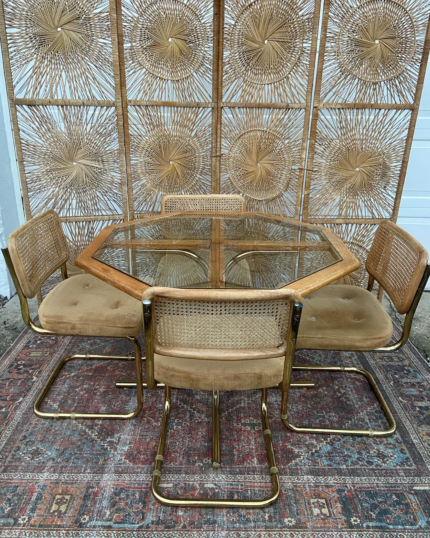 13. Bohemian Tapestry Drapes Over Sunlit Rattan Chairs
