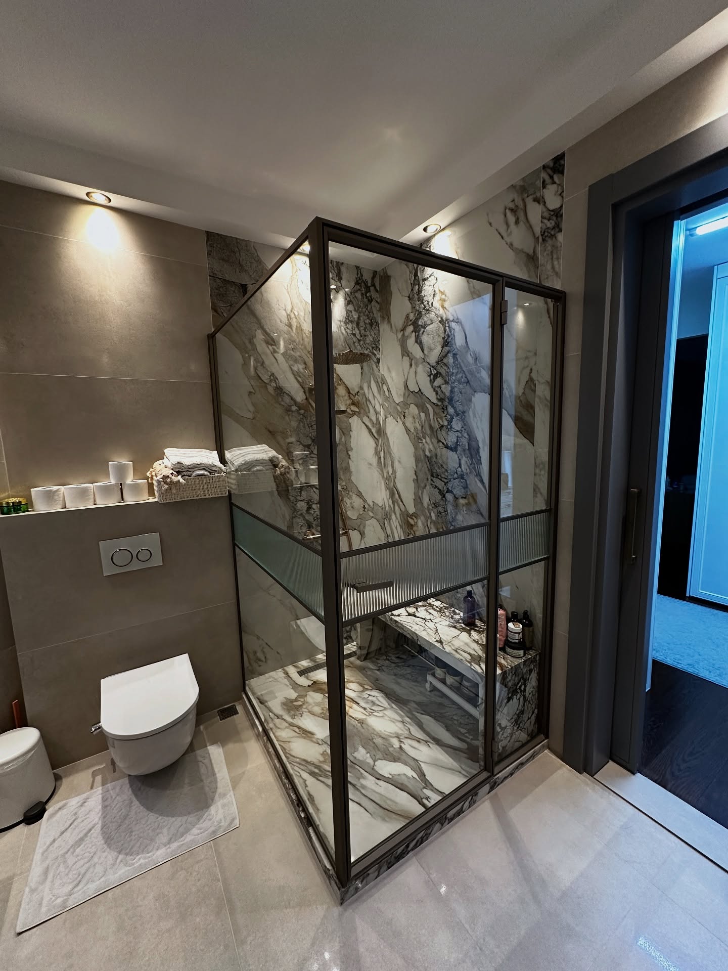 15. Sleek Black Framed Glass Panels with River Rock Floor In a Compact Urban Oasis