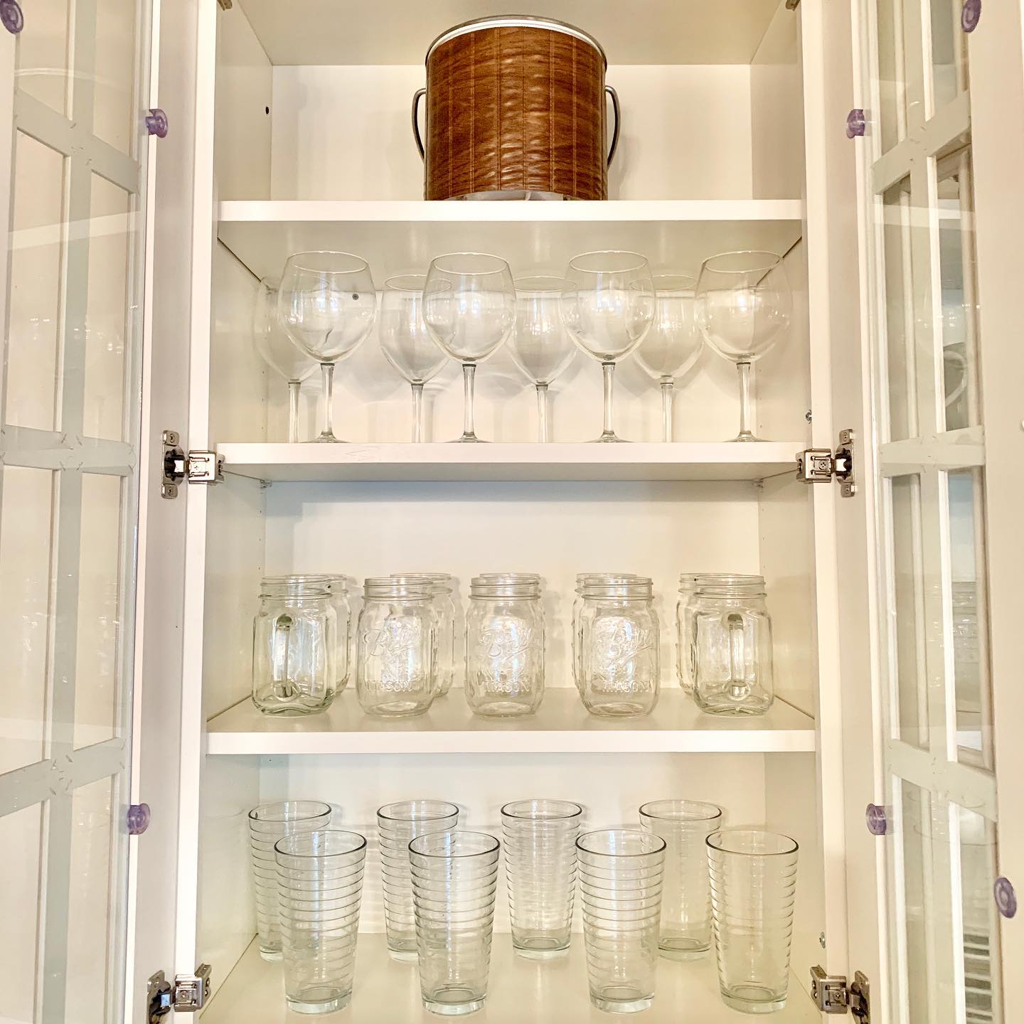 25. Sleek Pull-out Shelves with Geometric Spice Jars In a Glossy White Cabinet