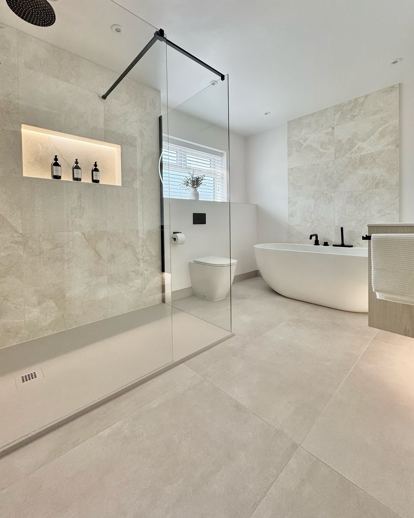 9. Metallic Mosaic Marvel with Dual Showerheads and Floating Shelf