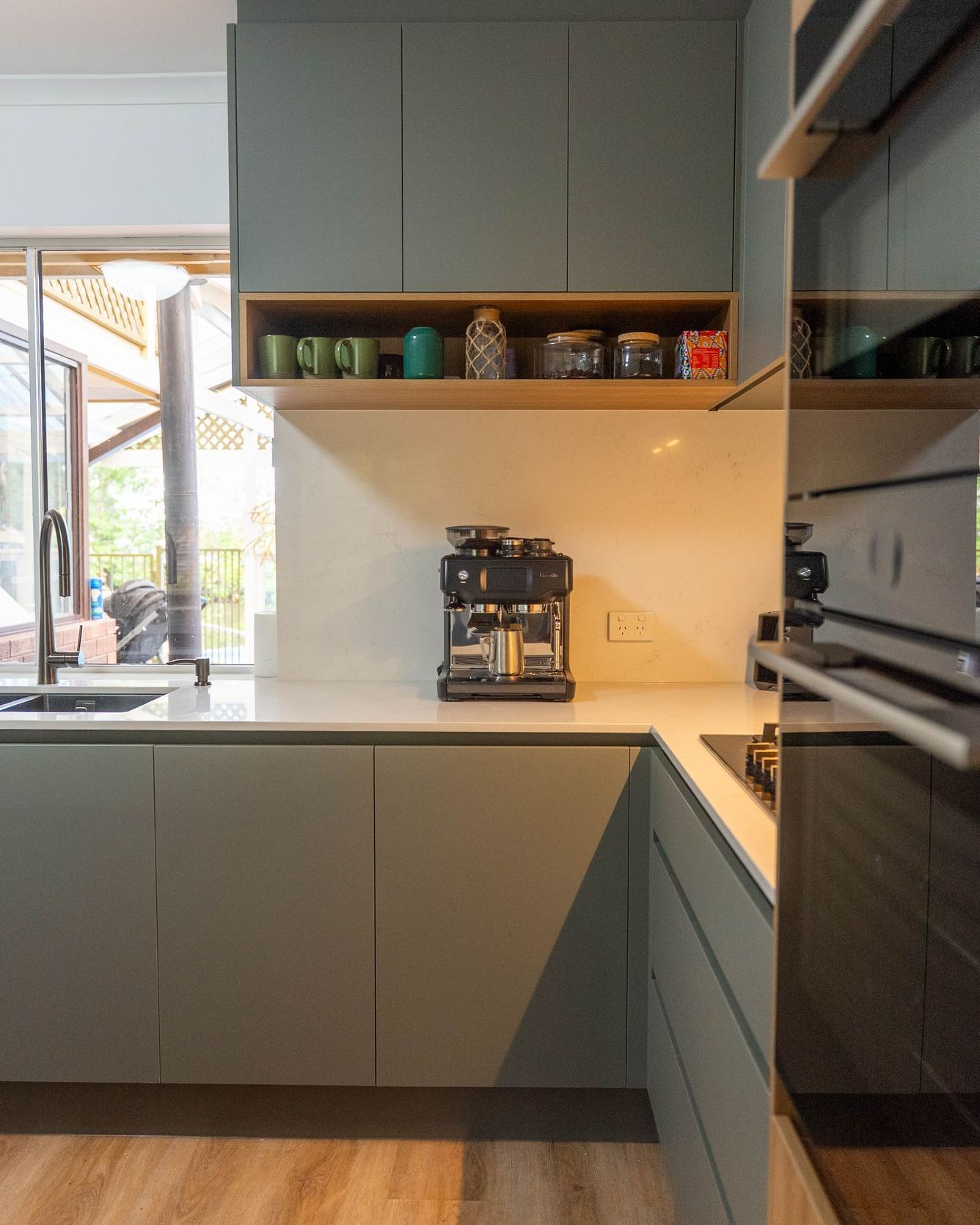7. Copper Pans and Greenery Cascade Above the Kitchen Cabinets