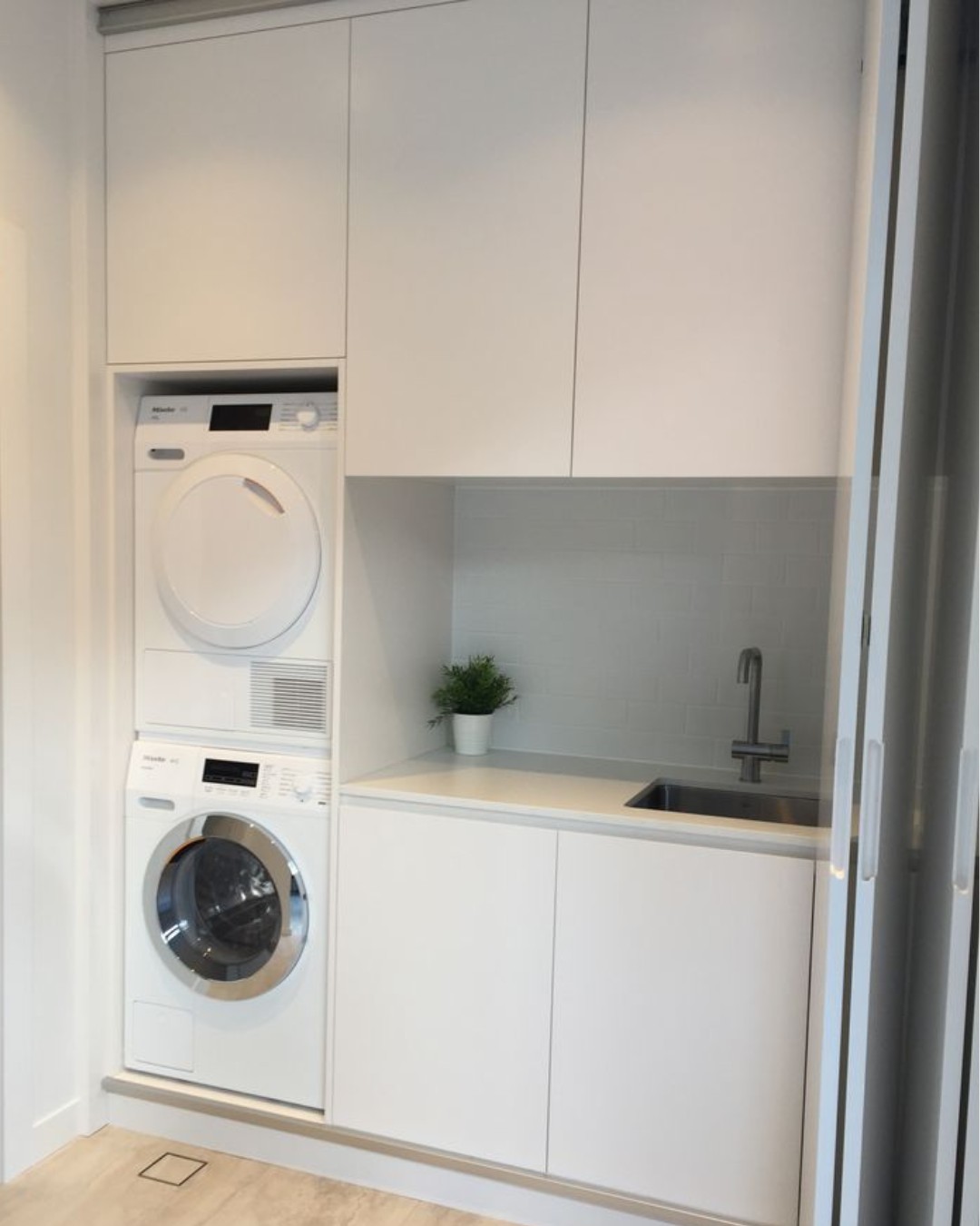 17. Sunlit Serenity: a Crisp White Cabinet with Geometric Glass Panels