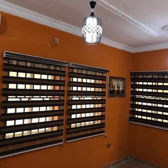 6. Venetian Sunset: Copper and White Striped Blinds with Geometric Wall Accents