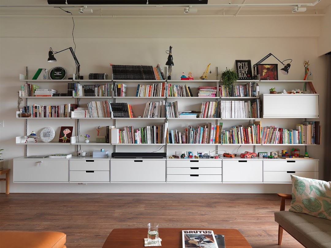 1. Tilted Tomes and Teal Accents: a Living Room Bookshelf with Asymmetrical Charm
